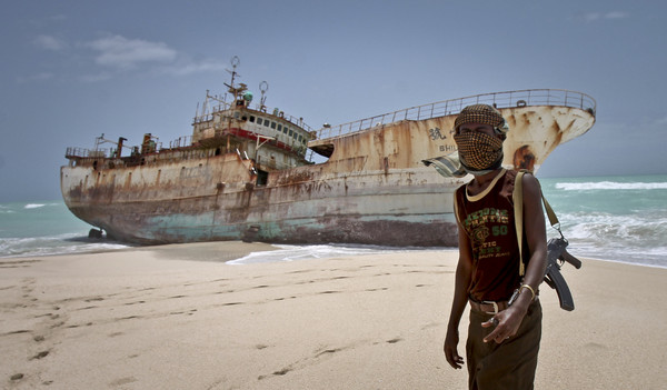 索馬利亞一名海盜站在一艘台灣籍漁船前。（圖／達志影像／美聯社）