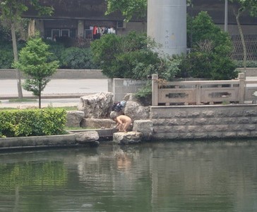 南京下关护城河,20日清晨竟然有个中年女子脱光光洗头洗澡.