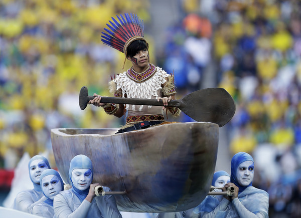 穿著巴西原住民服饰的舞者划著独木舟进场.(图/达志影像/美联社)