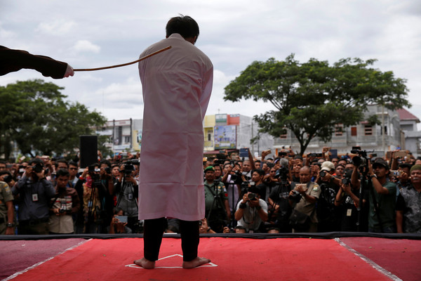 ▲印尼亞齊特區（Aceh）有2名男同志發生性行為，23日遭到公開鞭刑。（圖／路透社）