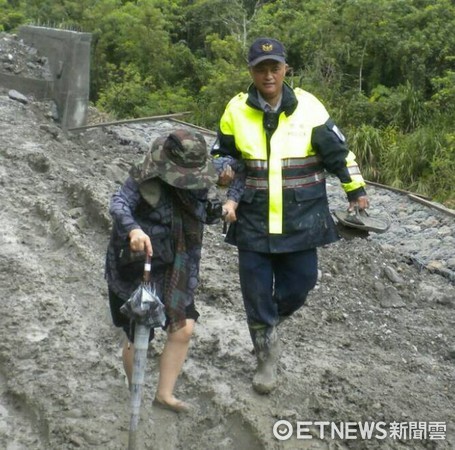 台東瑞源派出所員警將受困老夫妻攙扶下車，並通知拖吊車前來，順利協助遊客脫離險境。（圖／台東縣警察局提供）