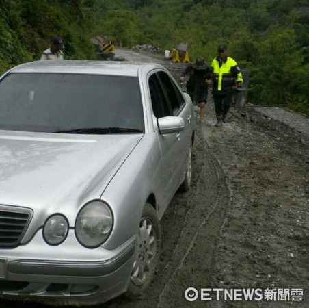 台東瑞源派出所員警將受困老夫妻攙扶下車，並通知拖吊車前來，順利協助遊客脫離險境。（圖／台東縣警察局提供）