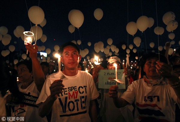 ▲▼泰國2014年大選前發生反政府與支持政府政營的衝突，而「白衫軍」成員點蠟燭守夜，呼籲民主選舉，結束政治爭端。（圖／視覺中國CFP）