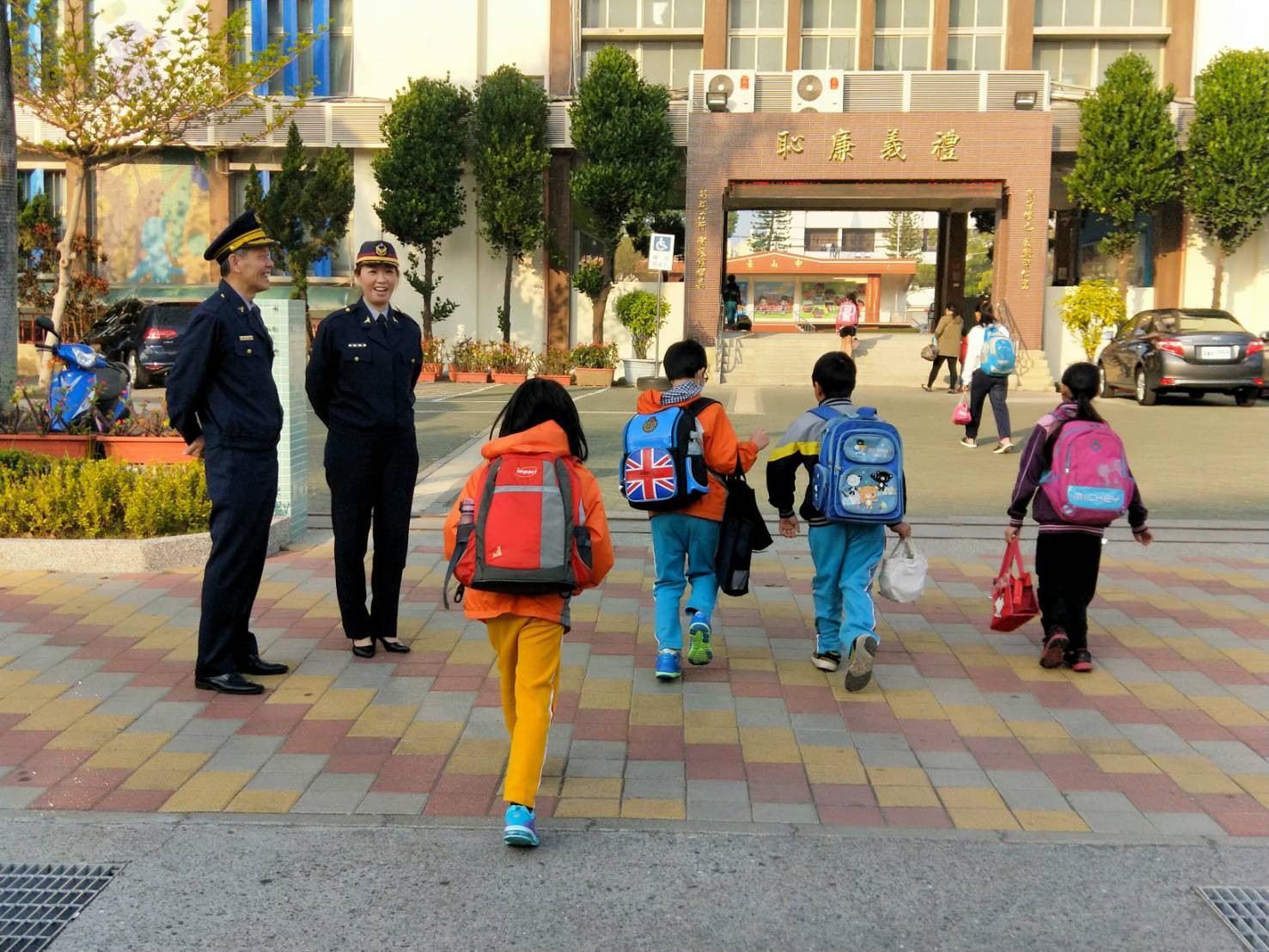 ▲台南市婦幼警察隊隊長陳福和、警員奚翠蘭，在校門口進行護童。（圖／警方提供）