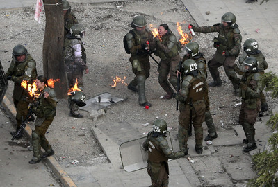 汽油彈直接砸臉！2女警頭上爆炸著火　智利示威現場影片曝光