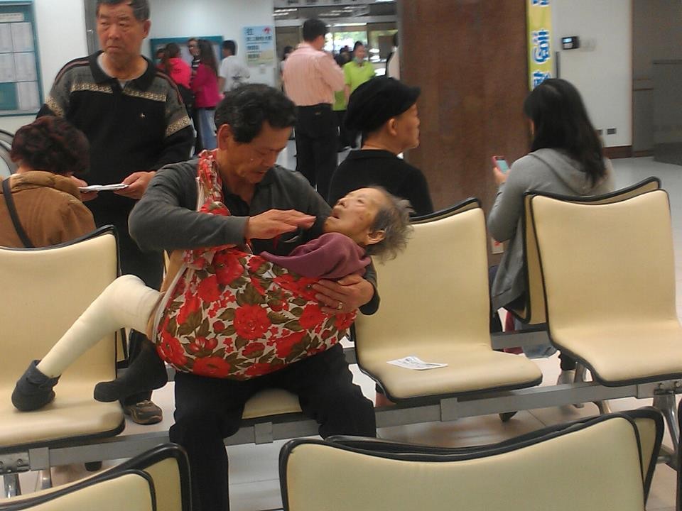 「孝行哥」把年邁又行動不便的媽媽背在胸前，細心、耐心的呵護畫面令人感動。(圖／取自周雨膧臉書)