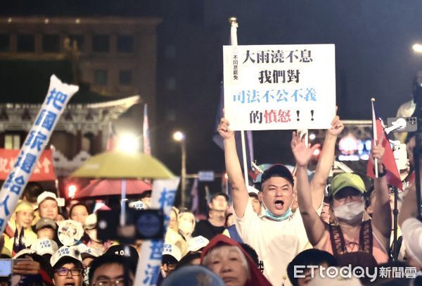 ▲國民黨舉辦「不同意罷免」選前之夜，參與民眾舉牌控訴「司法不公」。（圖／記者徐文彬攝）