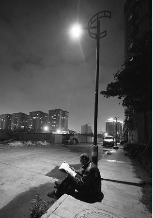 饿肚子也要看!拾荒老翁省饭钱买书报 每晚路灯下看书